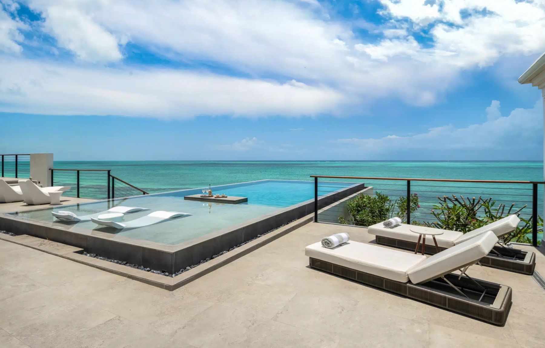 Sun loungers sit adjacent to the swimming pool 